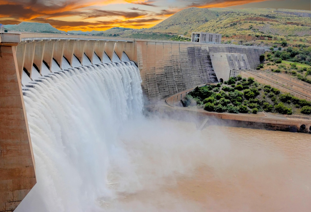 Large dam with water flowing over the barrier.