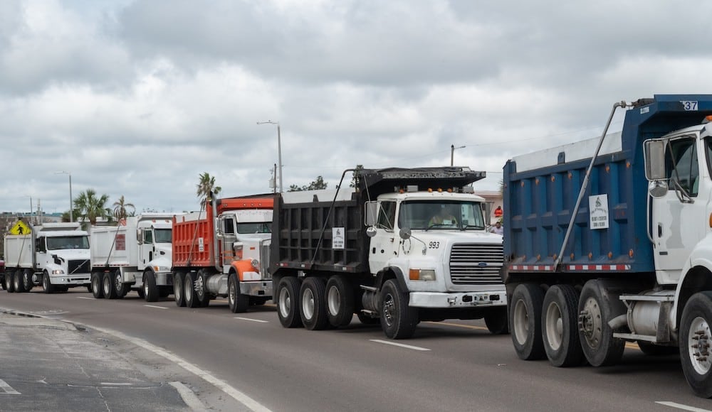 Dump trucks lined up to help assist with a debris management plan devised after a natural disaster.