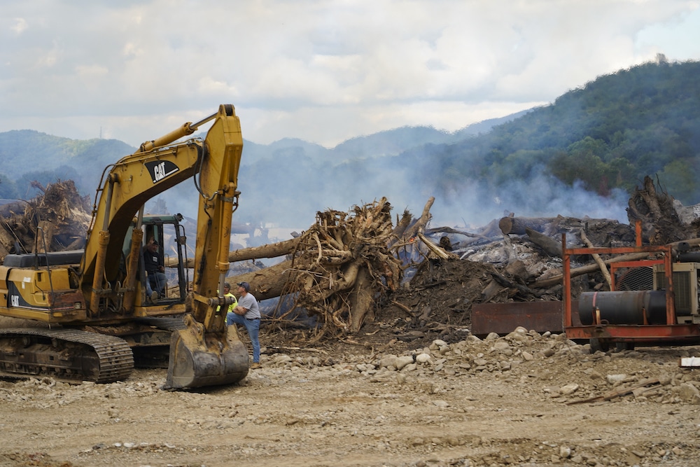 Heavy machinery being used to cleanup debris form a natural disaster.